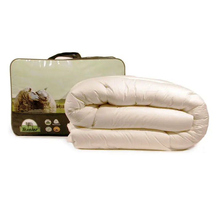 A beige Texeler Multi Choice comforter displayed in front of its packaging, which features an image of sheep on a green landscape. The comforter appears to be made of cotton and wool. 600 gram 